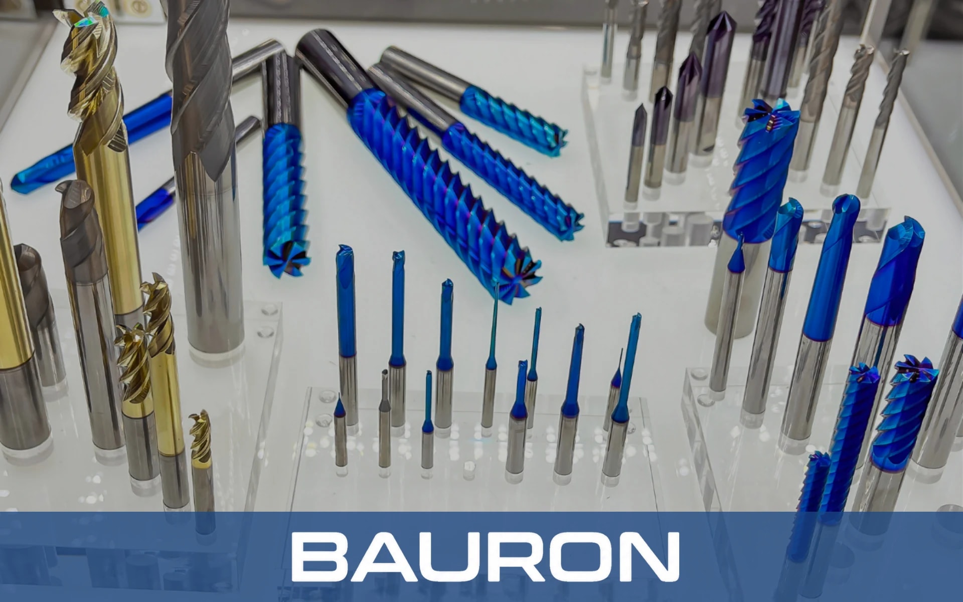 Blue- and gold-coated carbide end mills displayed in acrylic tool stands