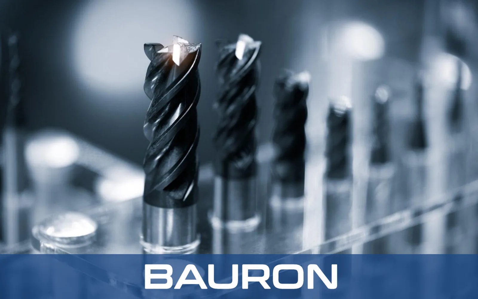 Black-coated helical end mills standing upright in a tool rack